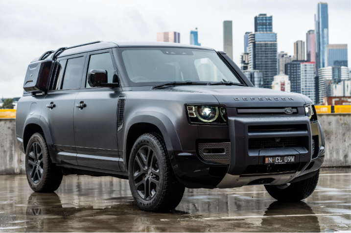 Black Land Rover Defender car SUV parked outdoors showcasing its bold design and premium styling.